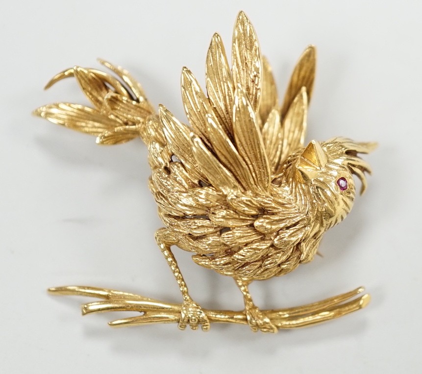 A 1960's Boucheron of Paris 18ct gold and ruby set brooch, modelled as a bird upon a branch, signed, width 43mm, gross weight 20 grams, with Boucheron box.